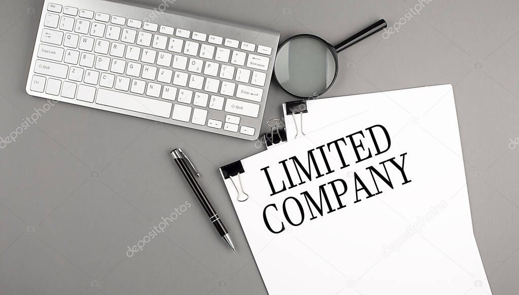 LIMITED COMPANY text on a paper with keyboard, magnifier and pen. Business concept