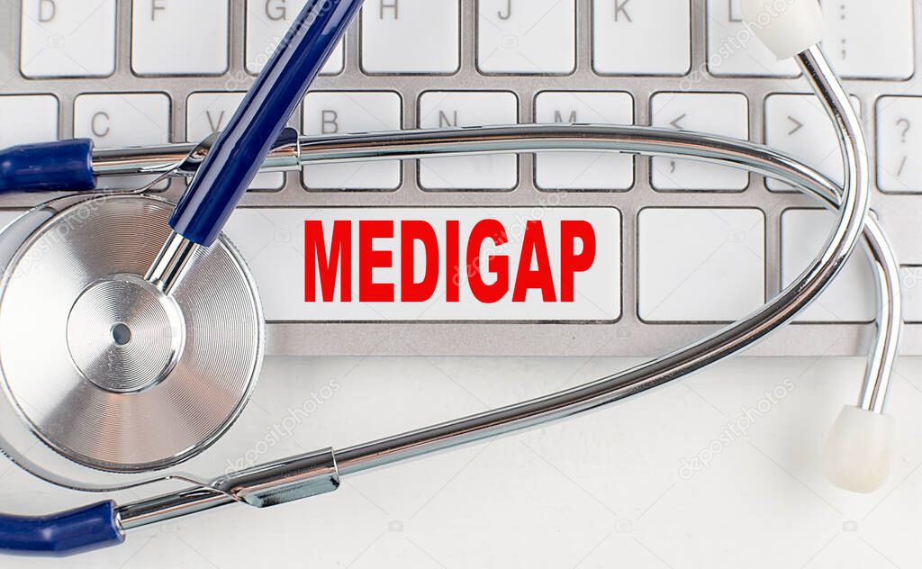 MEDIGAP text on a keyboard with stethoscope , medical concept