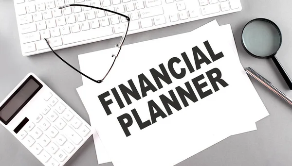 Finanční Planner Text Papíře Šedém Pozadí Blízkosti Kalkulačky Bílé Klávesnice — Stock fotografie