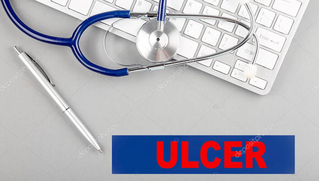 ULCER word with Stethoscope on a keyboard on grey background