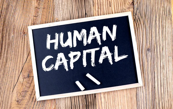 HUMAN CAPITAL text on chalkboard on the wooden background