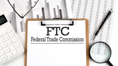 FTC-FEDERAL TRAD COMISSION ile kağıt hesap makinesi, kalem ve büyüteç ile haritada