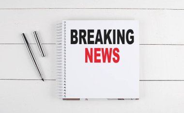 Tahta arka planda bir deftere yazılmış Kırıcı Haberler metni