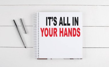 Hepsi senin ellerinde. Ahşap arka planda bir deftere yazılmış.