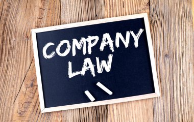 Ahşap arkaplandaki karatahtadaki COMPANY Yasa metni
