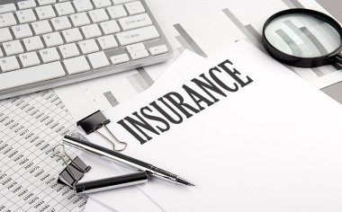 Grafikli ve klavyeli bir kağıt üzerinde INSURANCE metni, iş konsepti