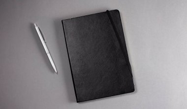 Gri arkaplanda siyah defter. Boşluğu kopyala