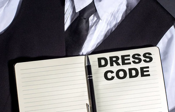 DRESS CODE text on a notepad with black and white clothes