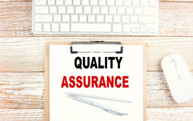 Pano üzerinde ahşap zemin üzerinde klavye ile nitelik ASSURANCE metni
