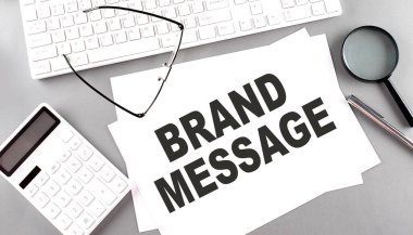 Klavyeli bir kağıt üzerinde BRAND MESSAGE metin, gri arkaplan üzerinde hesap makinesi
