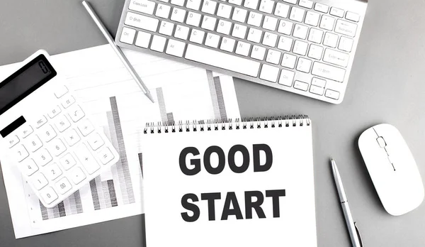 GOOD START text written on a notebook on grey background with chart and keyboard, business concept