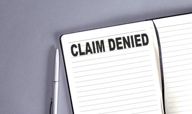 CLAIM DENIED kelime kalem ile defter üzerinde
