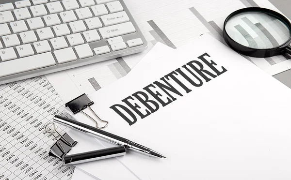 Grafikli ve klavyeli bir kağıt üzerinde DEBENTURE metni, iş konsepti