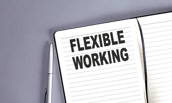 FLEXIBLE WORKING word on notebook with pen