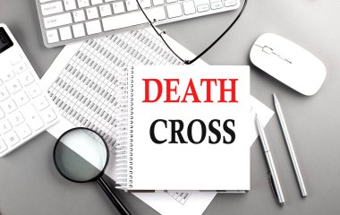 Gri bir arkaplanda klavye ve hesap makinesiyle not defterinde Ölüm Çapraz Metni