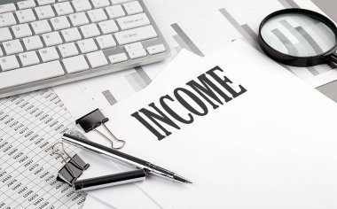 Grafikli ve klavyeli bir kağıt üzerinde INCome metni, iş konsepti