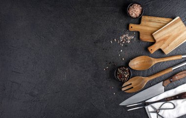 Tahta kesme tahtası, siyah arkaplanda salata için tahta kaşık, kopyalama alanı, üst görünüm