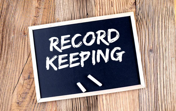 RECORD KEEPING text on chalkboard on the wooden background