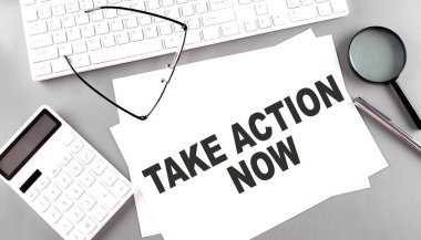 Eylem Al Şimdi klavyeli bir kağıt üzerinde metin, gri arkaplanda hesap makinesi