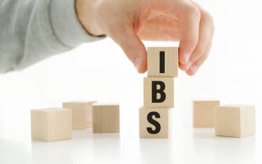 IBS - Alıngan Bağırsak Sendromu, tahta bloklara yazılmış yazı, beyaz arkaplan.