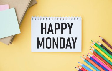 Mutlu pazartesiler. Ofis eşyalarıyla dolu boş bir albüm kağıdı ve mutlu pazartesi yazıları.