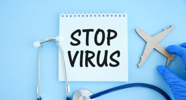 Steteskoplu bir masada üzerinde STOP VIRUS yazan kağıt. Tıbbi konsept