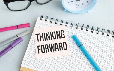 Ofis masasındaki pembe kâğıtta İleri Düşünme metni.