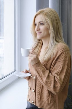 Kahve ayakta odanın penceresinde yakınındaki bir kadınla