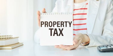 Property Vergi metni kalem ile not defterine yazılmış. Diyagramlı bir klasöre not düşür. Mali konsept.