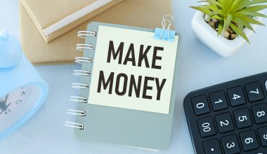 İş kavramları için para mesajı yaz. Sözcükler, ahşap bir masadaki deftere yazılmış para kazandırıyor. Yukarıdan görüntüle.