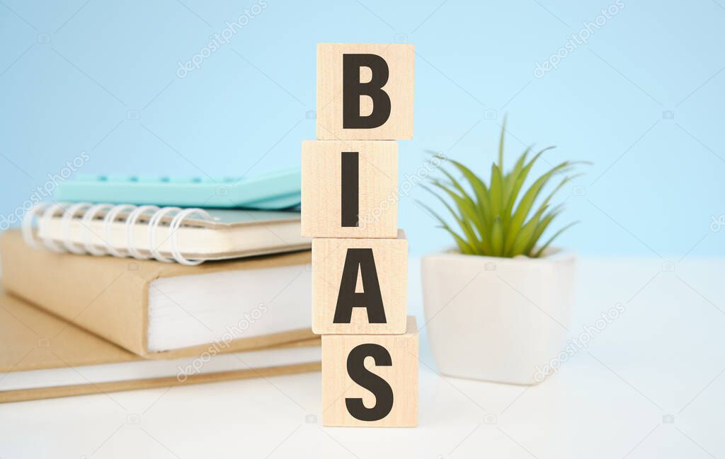 Bias - word from wooden blocks with letters, personal opinions prejudice bias concept, random letters around, white background