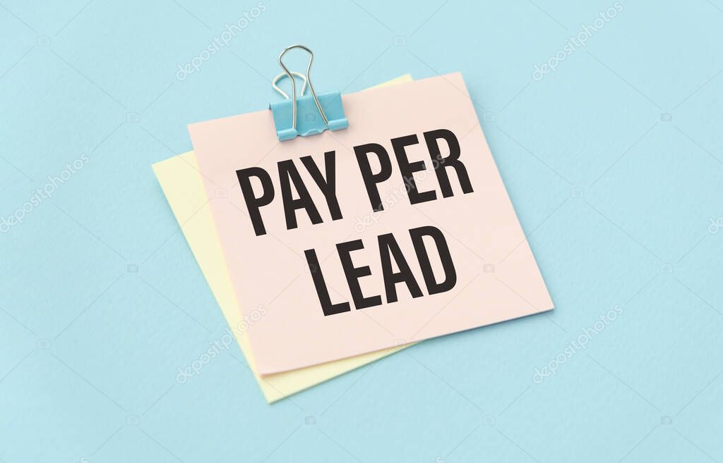 PAY PER LEAD text on white paper on blue background.