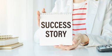 İş kadını ellerinde beyaz kart işareti ve başarı hikayeleri ile Gri Duvar ofis arka planında izole mesaj. Retro instagram tarzı resim. İlham gelişimi kavramı