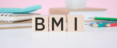 BMI kelimesi, arka planda steteskopun yanındaki tahta küplere yazılır. BMI - vücut kütle indeksi. Tıbbi konsept.