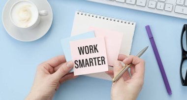 On a blue background, glasses, calculator, pen and notebook with the text WORK SMARTER