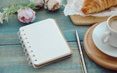 composition with a cup of coffee and a croissant on the table on the Place for the text