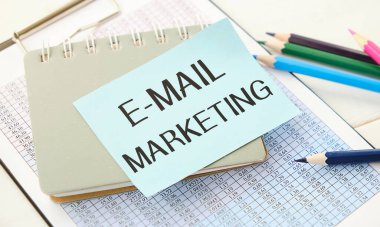 E-mail marketing and cup of coffee. E-mail marketing Written on white paper.