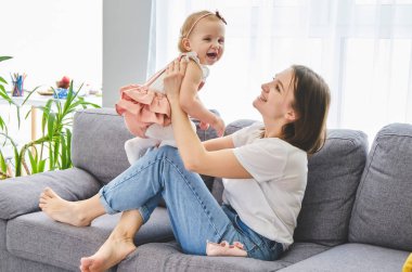 mutlu bir aile. Anne ve bebek kızı oynuyor, sarılma, öpüşme.
