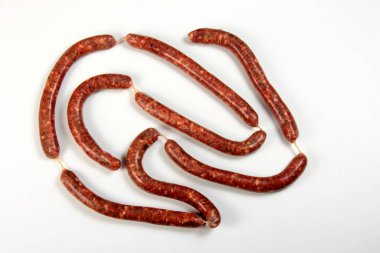 Beyaz arka plan üzerinde izole fesleğen yaprağı çiğ sosis.