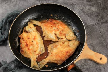 Metal kızartma tavasında üç kızarmış balık. Tavada kızarmış balık. 