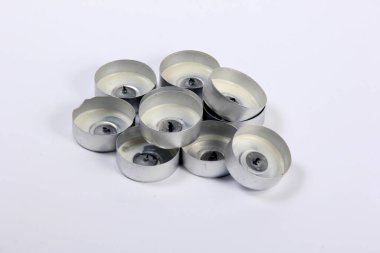 Beyaz arka planda birkaç tane kullanılmış çay mumu var. Çay Mumları için Boş Alüminyum Bardaklar İzole Edildi 