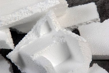 Siyah arka planda farklı şekillerde yapay köpük kağıtlar. Beyaz köpük parçacıkları yaklaşıyor. Parçalanmış köpük parçaları koyu arkaplanda izole edilmiş.