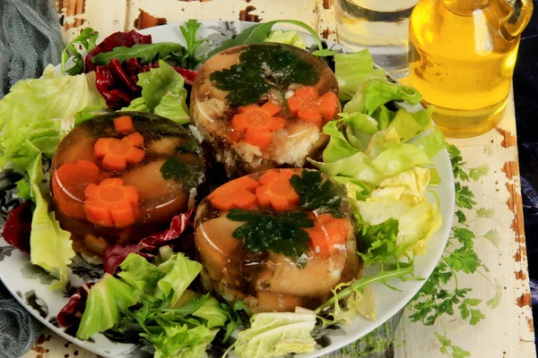 Meat aspic, jellied slow cooked meat on a plate.National Russian dish Holodec, jelly with parsley and carrots