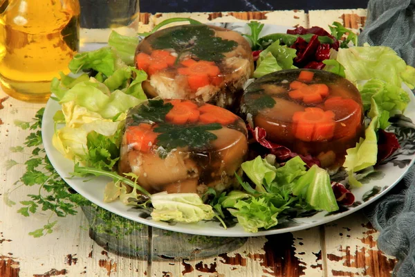 Meat aspic, jellied slow cooked meat on a plate.National Russian dish Holodec, jelly with parsley and carrots