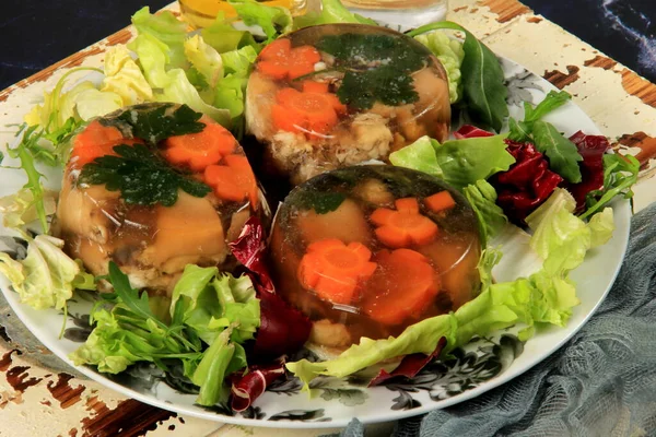 Meat aspic, jellied slow cooked meat on a plate.National Russian dish Holodec, jelly with parsley and carrots