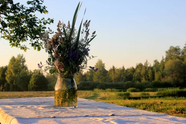 Egy Nagy Asztal Fehér Terítővel Egy Váza Rét Virágokkal Áll — Stock Fotó