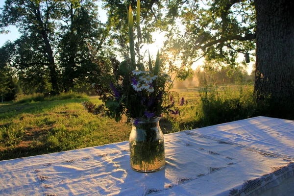 Egy Nagy Asztal Fehér Terítővel Egy Váza Rét Virágokkal Áll — Stock Fotó