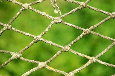 Close-up of an old net on a green blurred background, selective focus