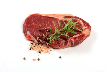 Raw sirloin beef steak with rosemary, pepper, salt and garlic on white background