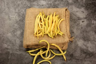 Fresh yellow beans on a wooden table background